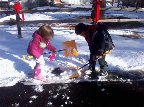 Two kids shoveling snow