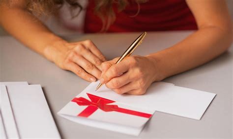 A person's hands writing card, envelopes