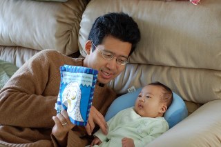 Adult reading to a baby on a couch