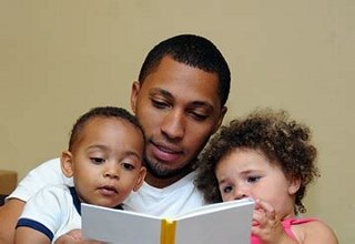 Adult reading with two toddlers