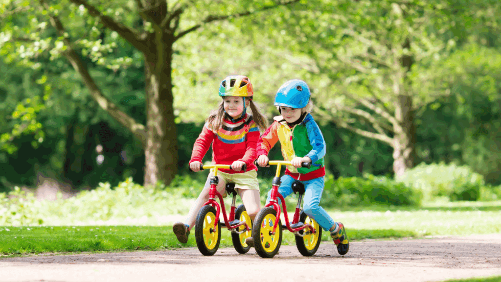 Two young children riding bikes, wearing with helmets