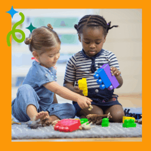 Two toddlers playing together with blocks