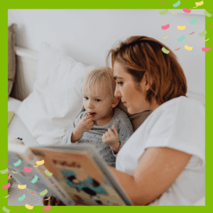 Parent reading a book to toddler in bed