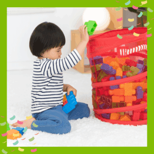 Toddler putting toys away