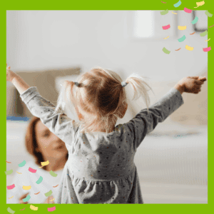 Back of a toddler with arms stretched out in the air - parent sitting on floor looking at child
