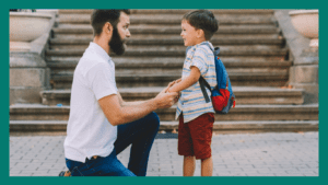 Parent kneeling down to child's eye level outside. Child is wearing a backpack and smiling.