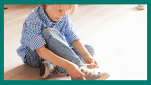 Kindergarten development: Kid tying shoe laces