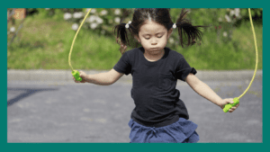 Kindergarten development: child skipping rope outside
