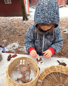 Child doing forest school table activities in winter
